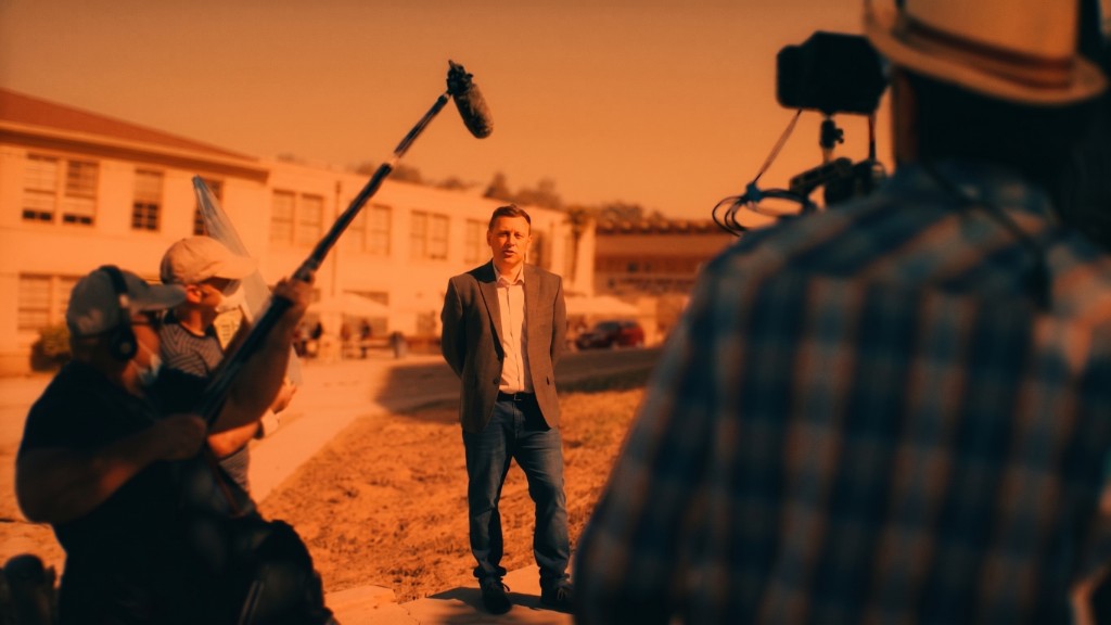 Steve Hayton on location with a professional film crew — boom operator and camera operator in foreground, golden hour light